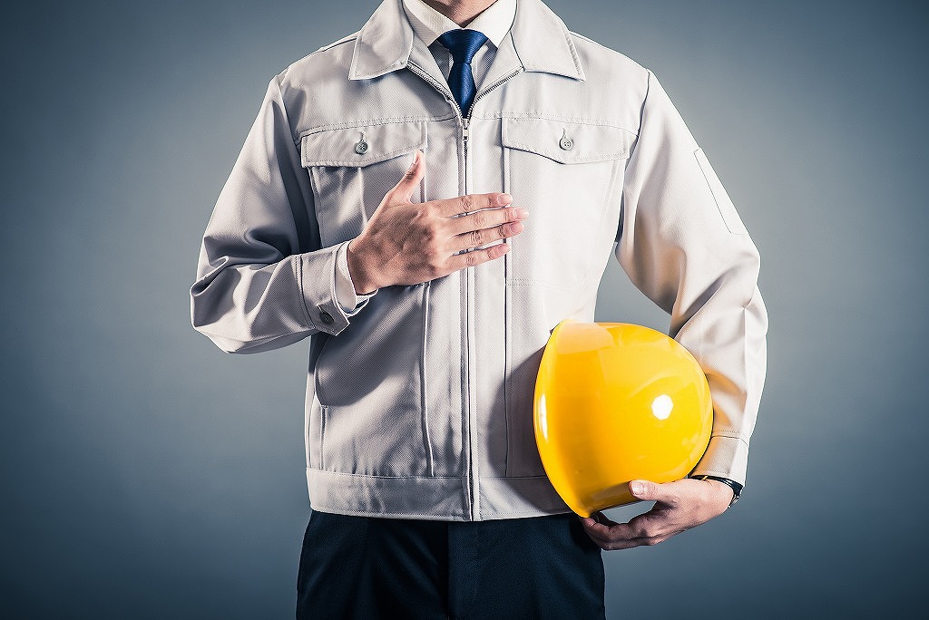 ヘルメットを抱える作業員