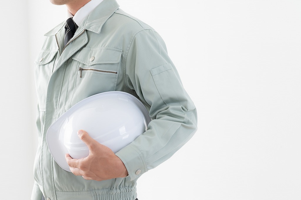 ヘルメットを抱える作業員